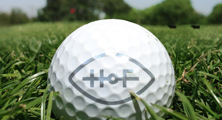 Golf ball with a logo on grass